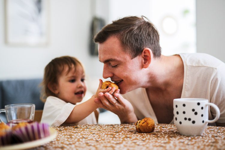 Parenting While in Recovery, young dad with his toddler daughter eating mini muffins together - parenting in recovery